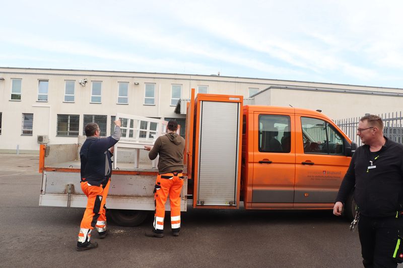 Werkstattkoordinator (re) hilft beim Aufladen der fertigen Bänke Werkstattkoordinator (re) hilft beim Aufladen der fertigen Bänke